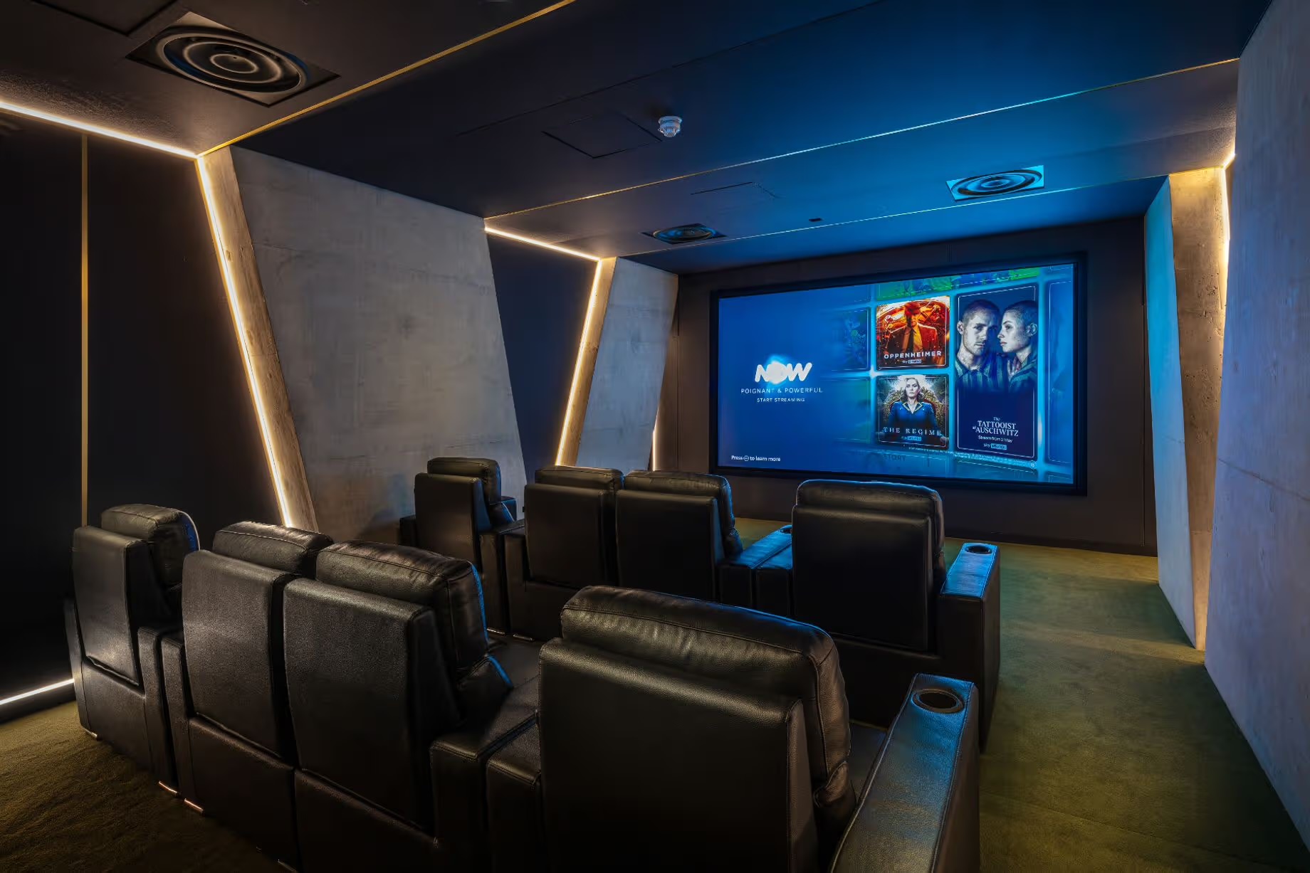 Cinema room with two rows of leather recliners facing a large widescreen