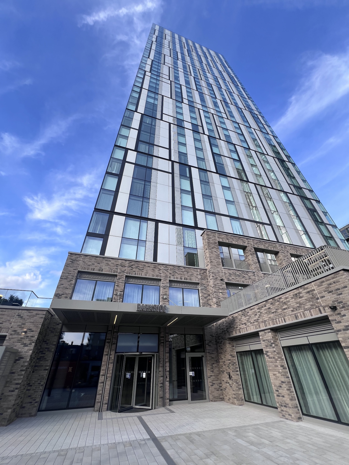 Upward view of the Bankside tower above its brick podium, with the entrance canopy lettered Bankside