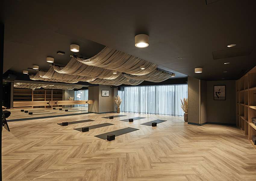 Yoga studio with mats and blocks laid out, a mirrored wall and a ballet barre