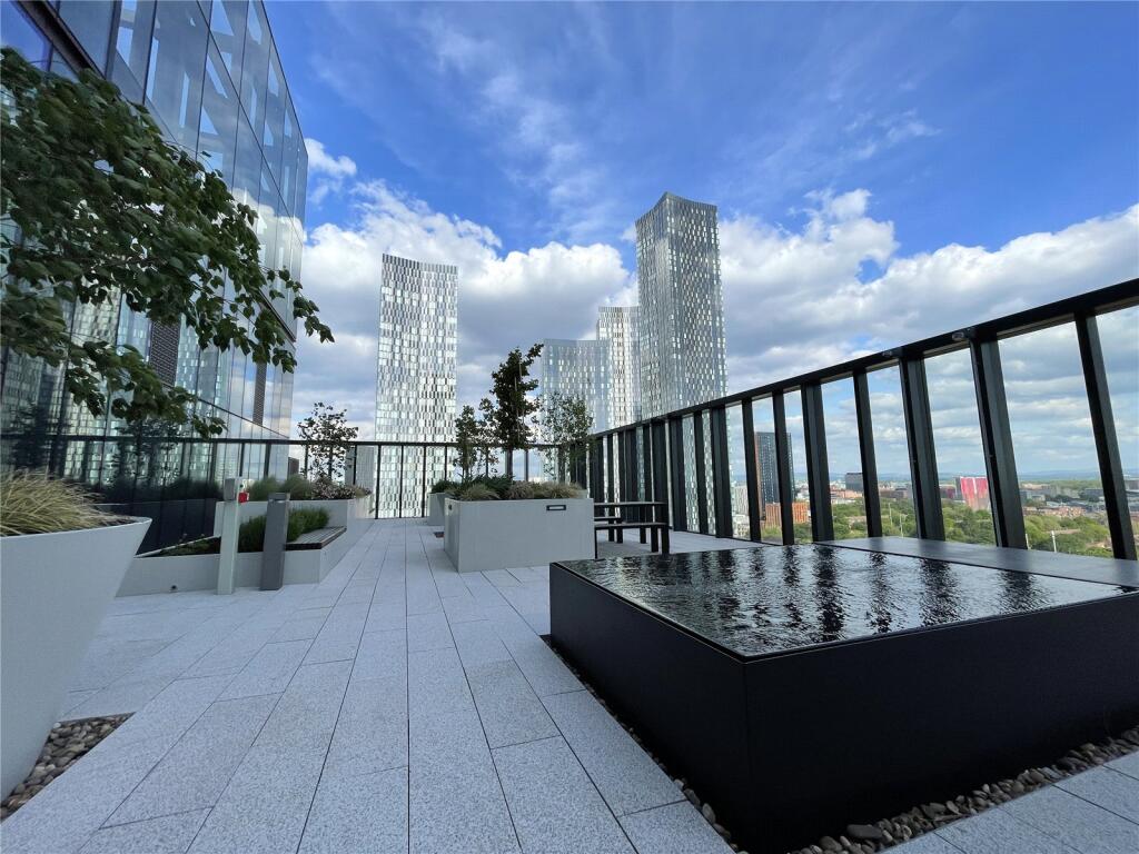 Rooftop terrace with water feature, planters and benches in the sun