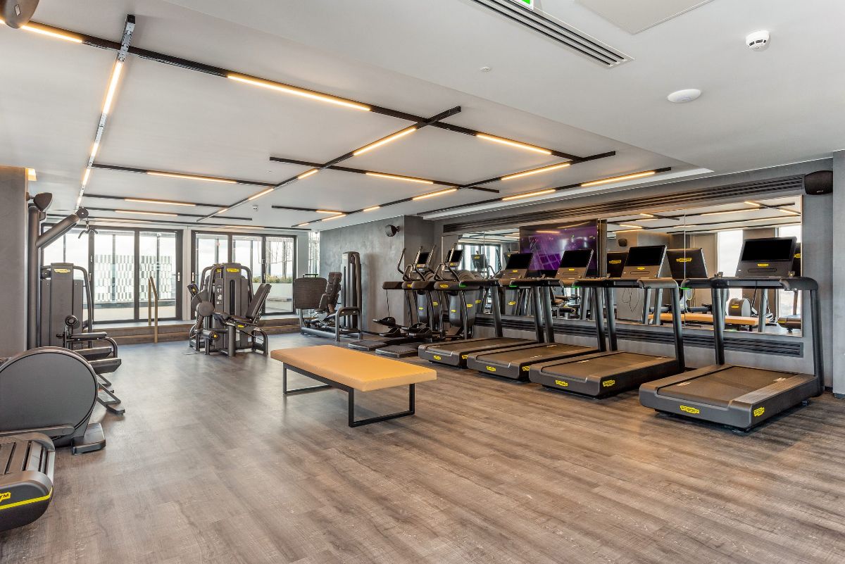 Gym with treadmills, cardio machines and a mirror wall