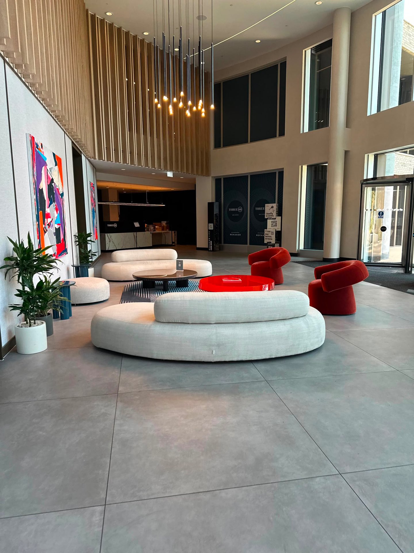 Three60 entrance lobby with concierge seating, artwork and pendant lighting