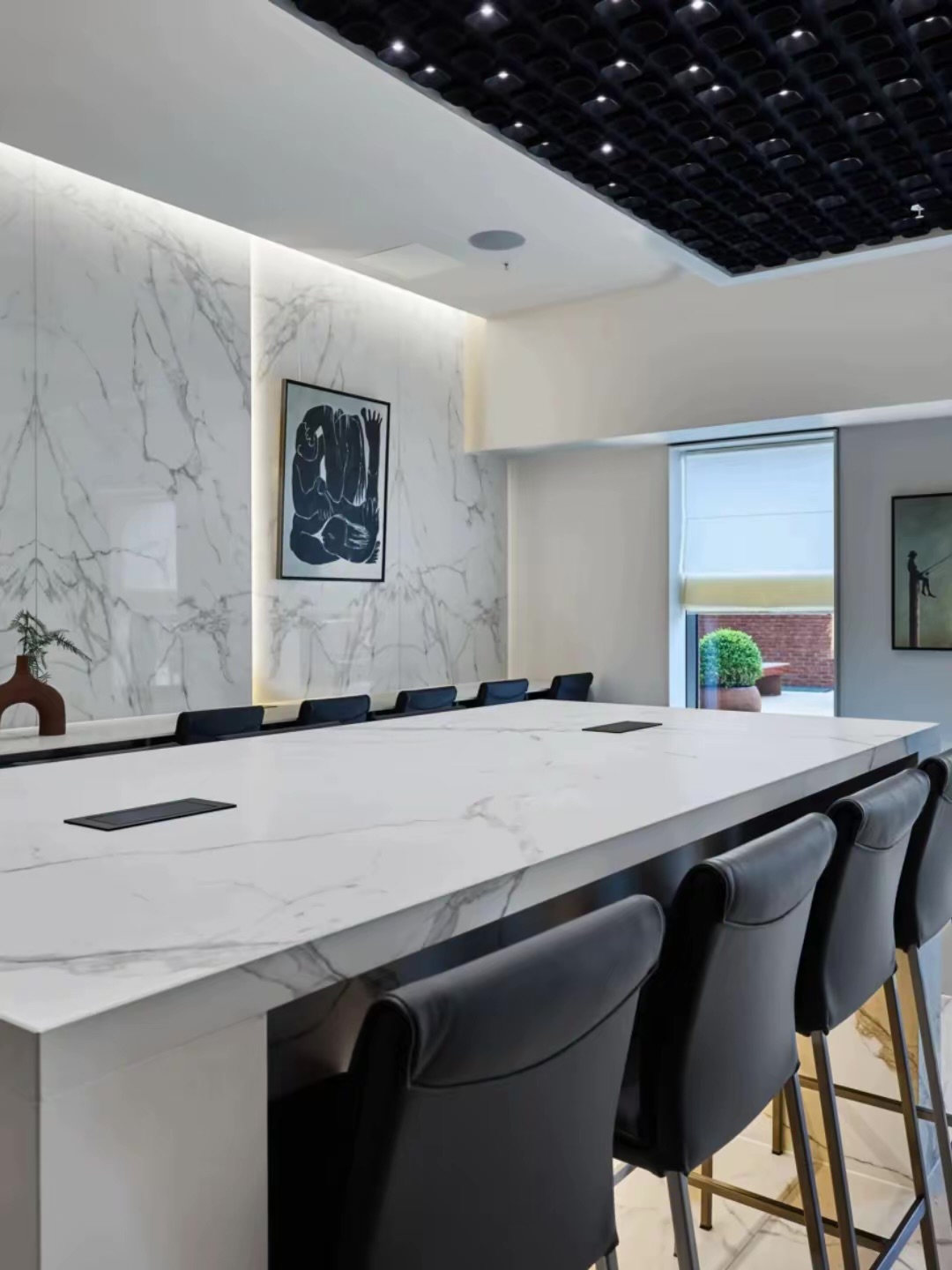 Communal room with a long marble-effect table and chairs