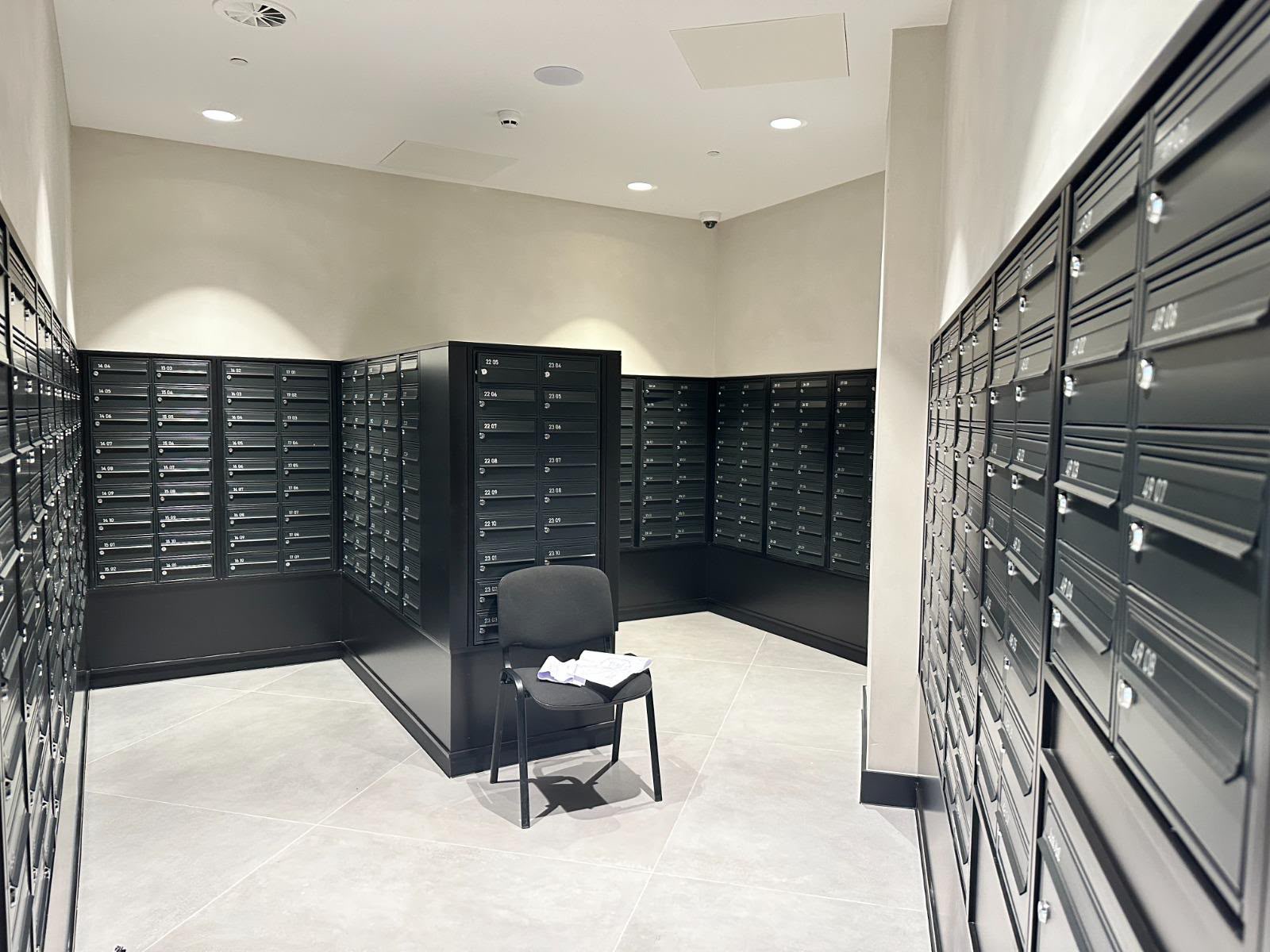 Residents' mail room with wall of post boxes and seating