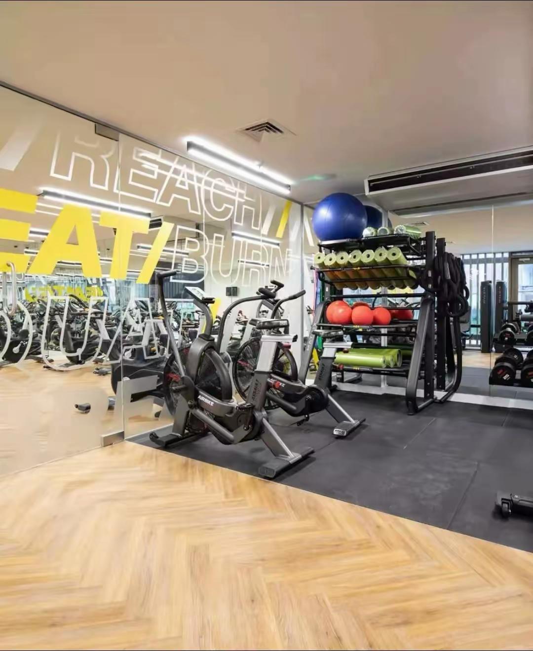 Residents’ gym with spin bikes, free weights, exercise balls and a motivational mirror wall