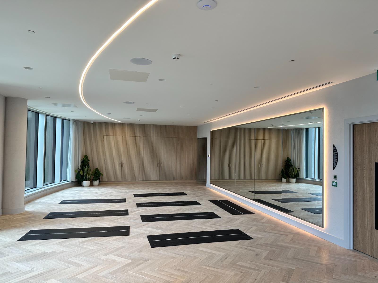 Yoga studio with mats, mirror wall and floor-to-ceiling windows