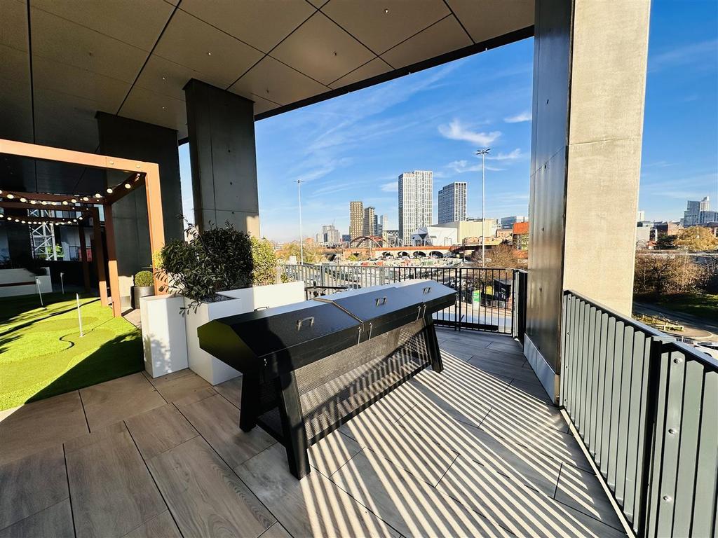 Covered terrace with a black metal console unit, the putting green and open views across the city skyline