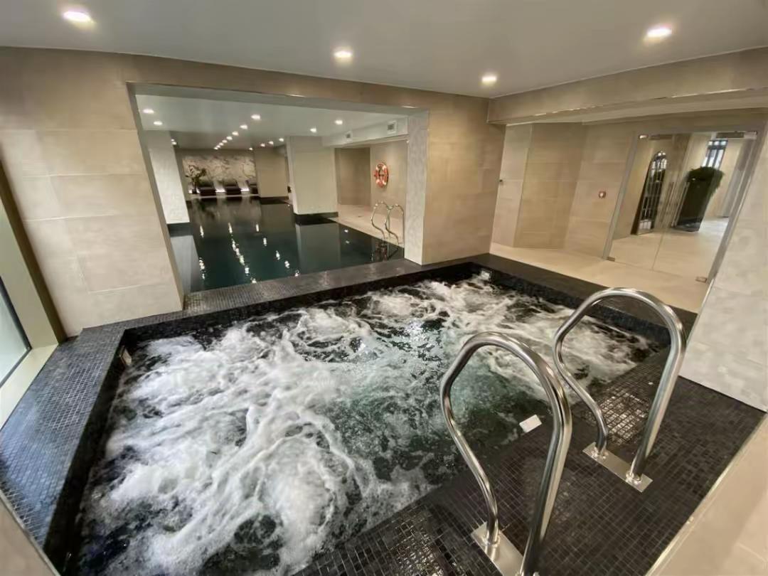 Indoor swimming pool with a bubbling hydrotherapy spa in the foreground