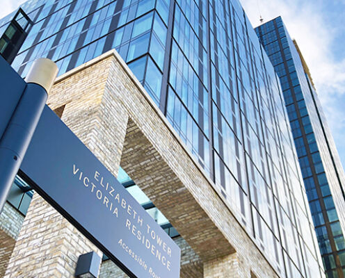 Street-level entrance sign for Elizabeth Tower and Victoria Residence with the towers behind