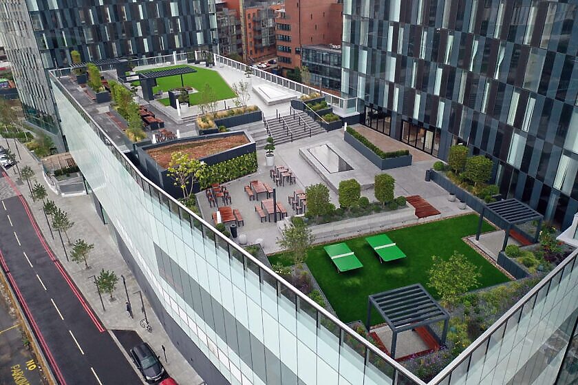 Aerial view of the landscaped rooftop terrace with lawn, pergolas, table tennis, planting and outdoor seating between the towers